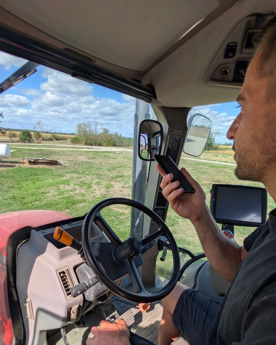 Un agriculteur dicte une intervention à son téléphone, dans la cabine du tracteur